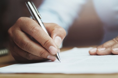 man writing on a document