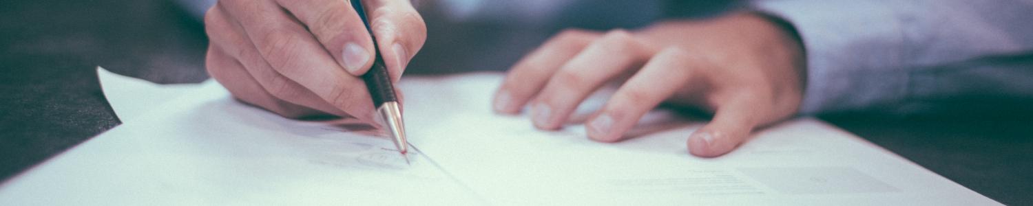 man signing paper